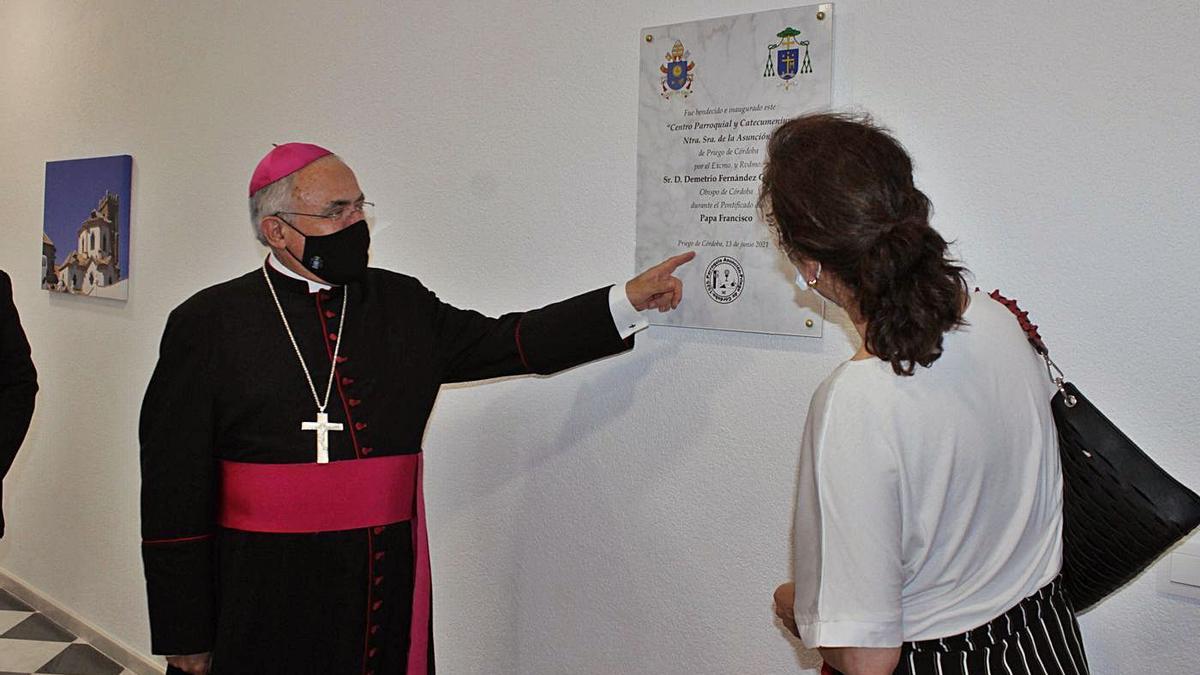 El obispo de Córdoba, Demetrio Fernández, ante el azulejo instalado en el acceso al centro parroquial.