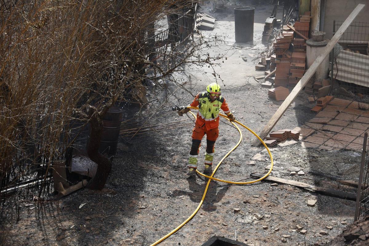 Un bombero refresca una zona incendiada en el término municipal de Gátova, en una imagen captada el pasado domingo.
