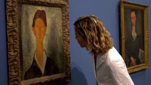 Una mujer contempla el cuadro de Modigliani Joven con el pelo rojo