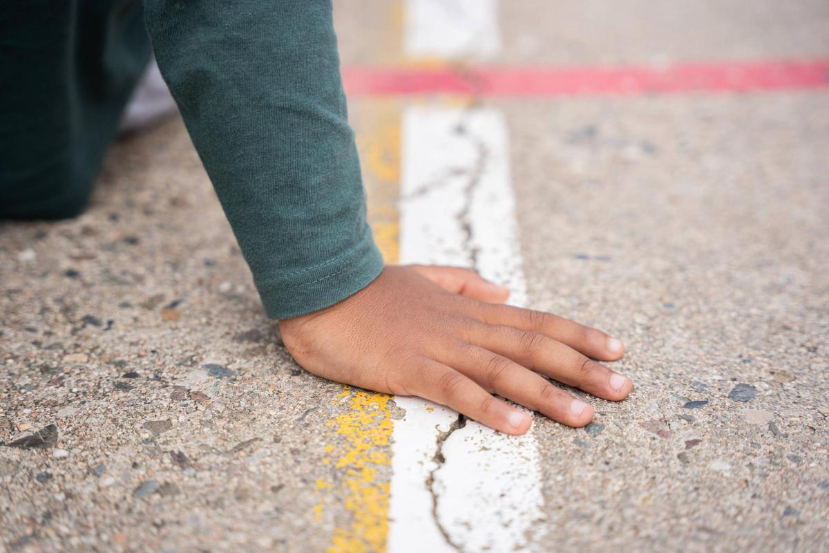 Mano de un niño en la pista de un colegio en Catalunya.