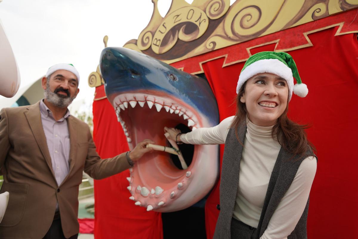 Eduardo Nogués y Marta Calabuig junto al buzón navideño en forma de tiburón de Oceanogràfic.