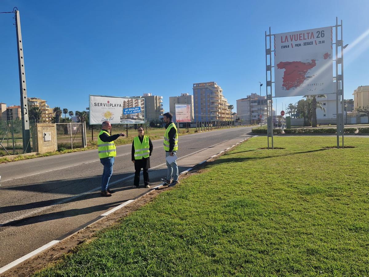 El alcalde con técnicos del ayuntamiento ante el cartel que ya anuncia la llegada de la Vuelta a la playa de Xeraco