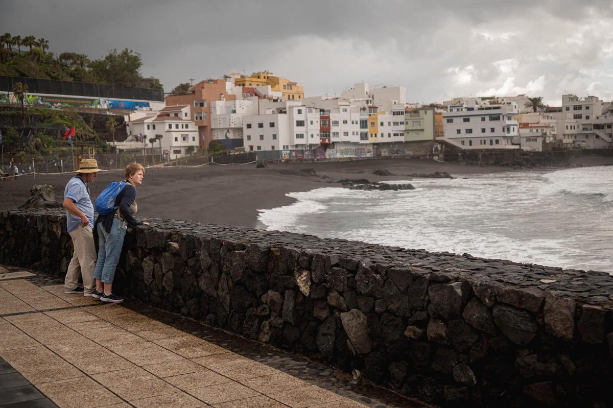 Dos turistas paseando por la playa de Punta Brava