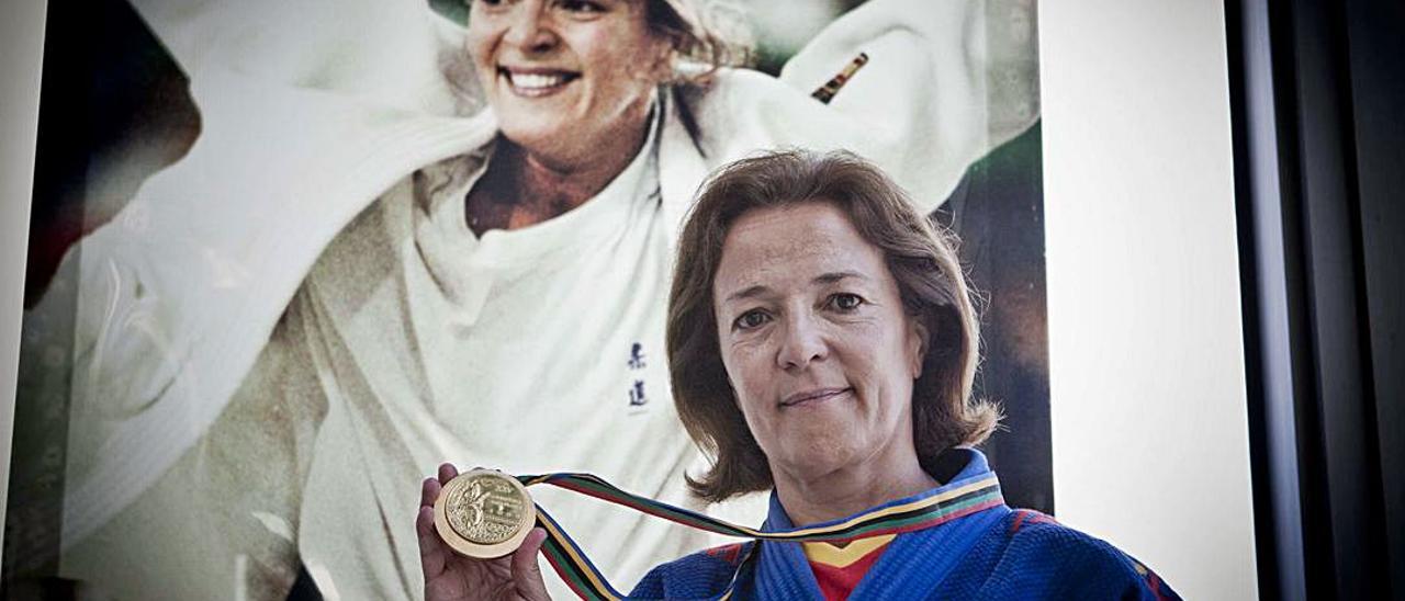 Miriam Blasco posacon la medalla de oro y una imagen de su triunfo en Barcelona 92