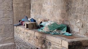 Dos personas sin hogar duermen sobre cartones en el castillo de Dalt Vila.