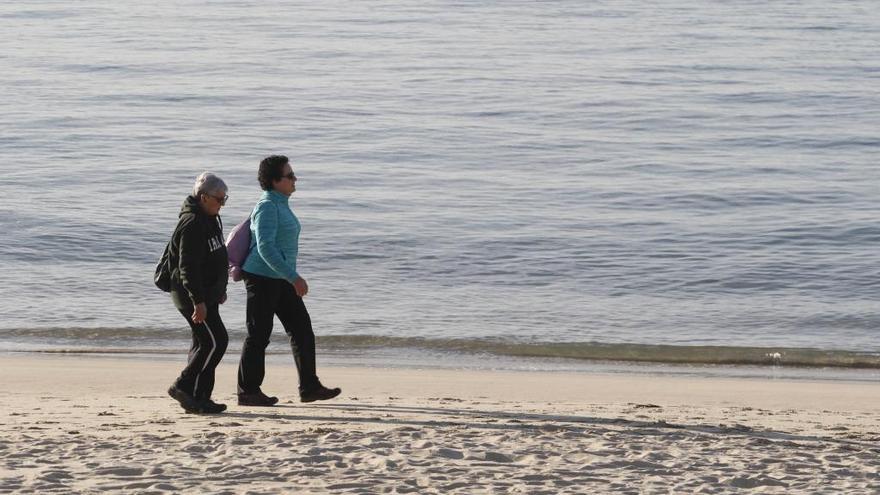 Dos viguesas pasean por la playa de Samil. // A. Villar