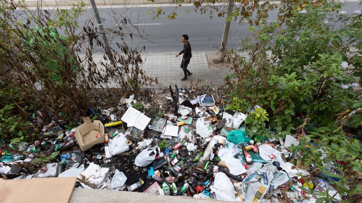 Un joven pasa junto a una zona llena de basura en Colonia Requena.