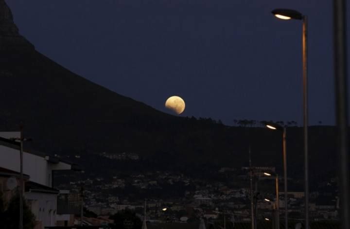 The moon is partially covered by the Earth's shadow during a total lunar eclipse in Cape Town