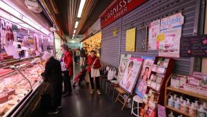 Una carnicería cerrada junto a otros comercios abiertos en el mercado de Lesseps, en Barcelona.