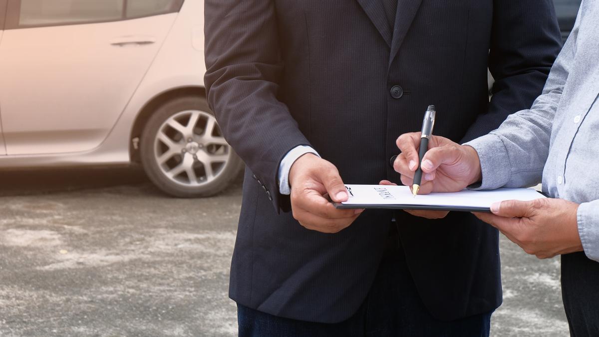 Loss Adjuster Insurance Agent Inspecting Damaged Car.