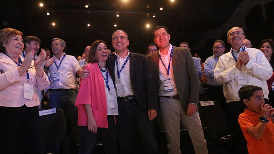 Juanma Moreno, Elías Bendodo y Patricia Navarro saludan desde el escenario del salón de actos que acoge el congreso del PP.