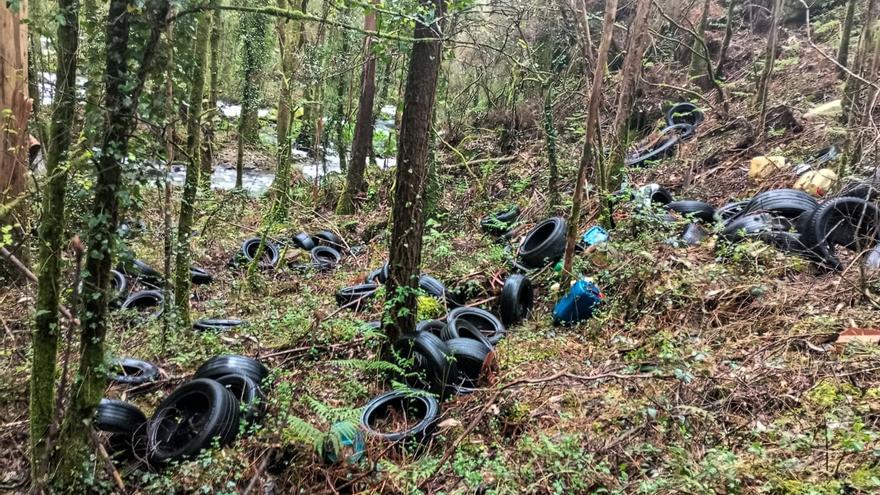 Arroxan ducias de pneumáticos á beira do río Grande, en Vimianzo