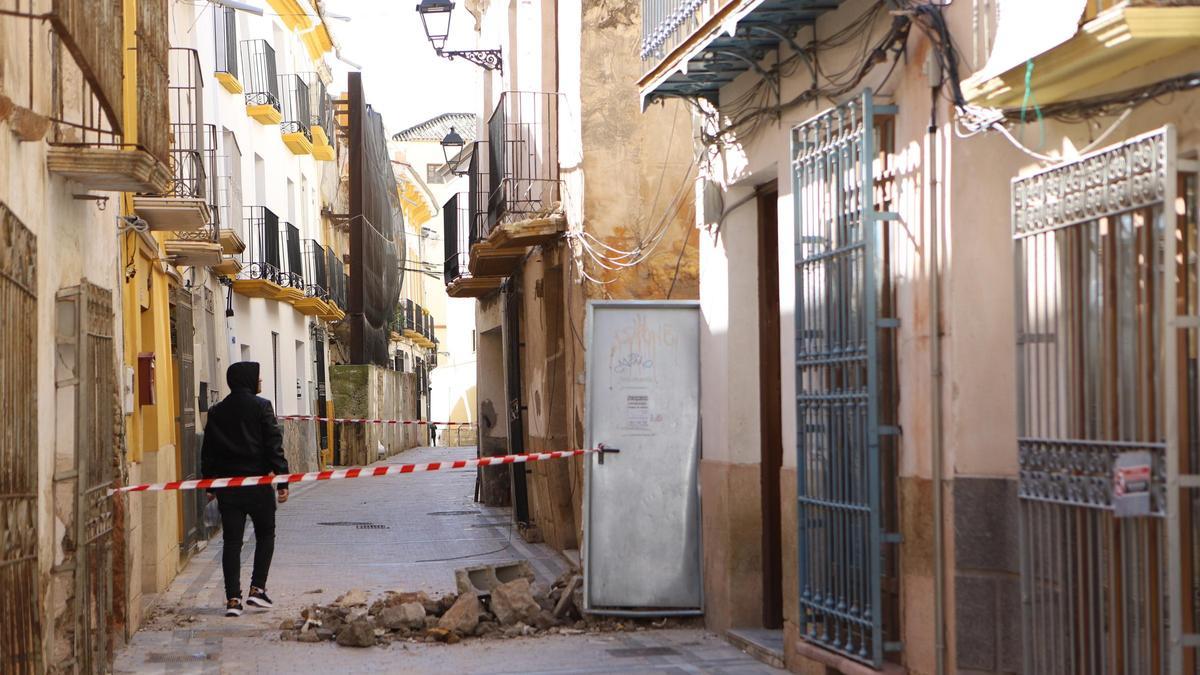 Un joven contempla la casa derrumbada en el Casco Histórico de Lorca.