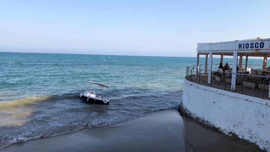 Imagen del barco de recreo con motor fueraborda encallado junto al tintero en la playa del Cura.