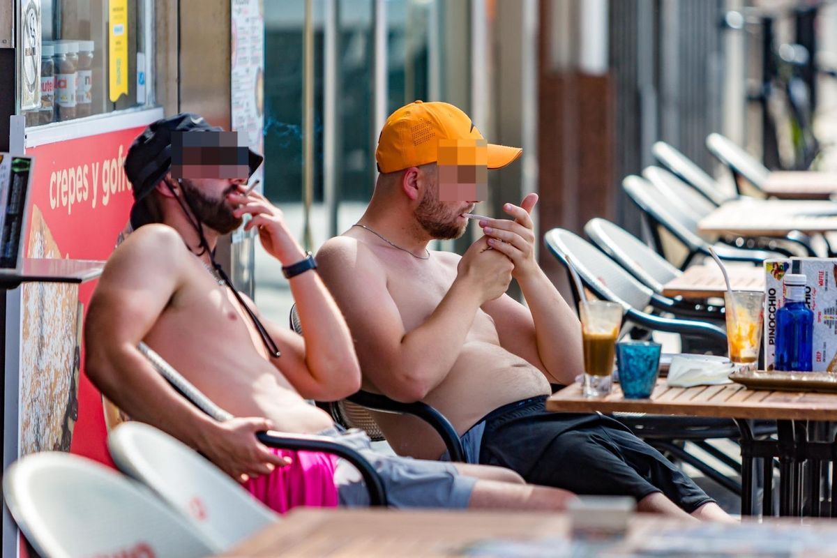 Dos jóvenes fuman en una terraza en Benidorm