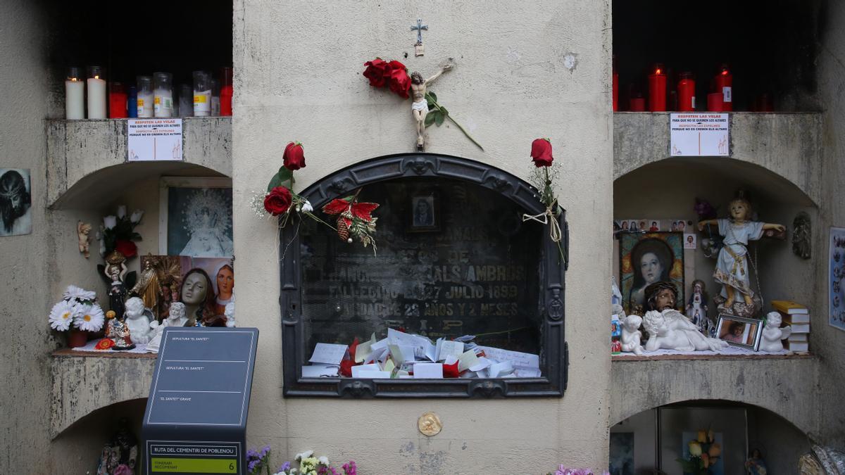 Tumba del Santet del Poblenou, con la lápida en formato urna para recoger las peticiones de sus devotos. Los 12 nichos que la rodean están llenas de velas, figuras y hasta fotos anónimas enmarcadas.