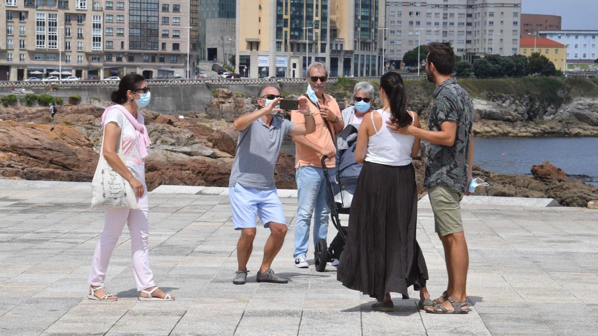 Ciudadanos con mascarilla en el paseo marítimo de A Coruña.