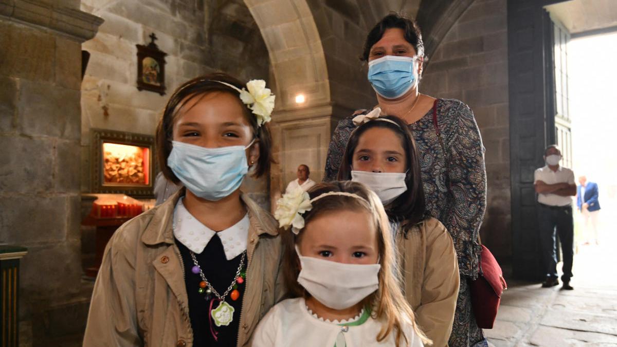 Una familia con mascarillas en una misa en Poio. // G. Santos