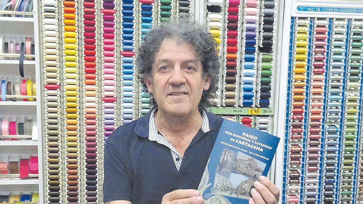 Paco López Mengual posa en su  mercería con su último libro