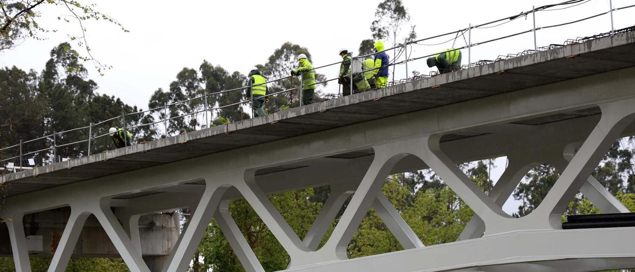 Operarios trabajando sobre la base del tablero del puente de Santa Marta.