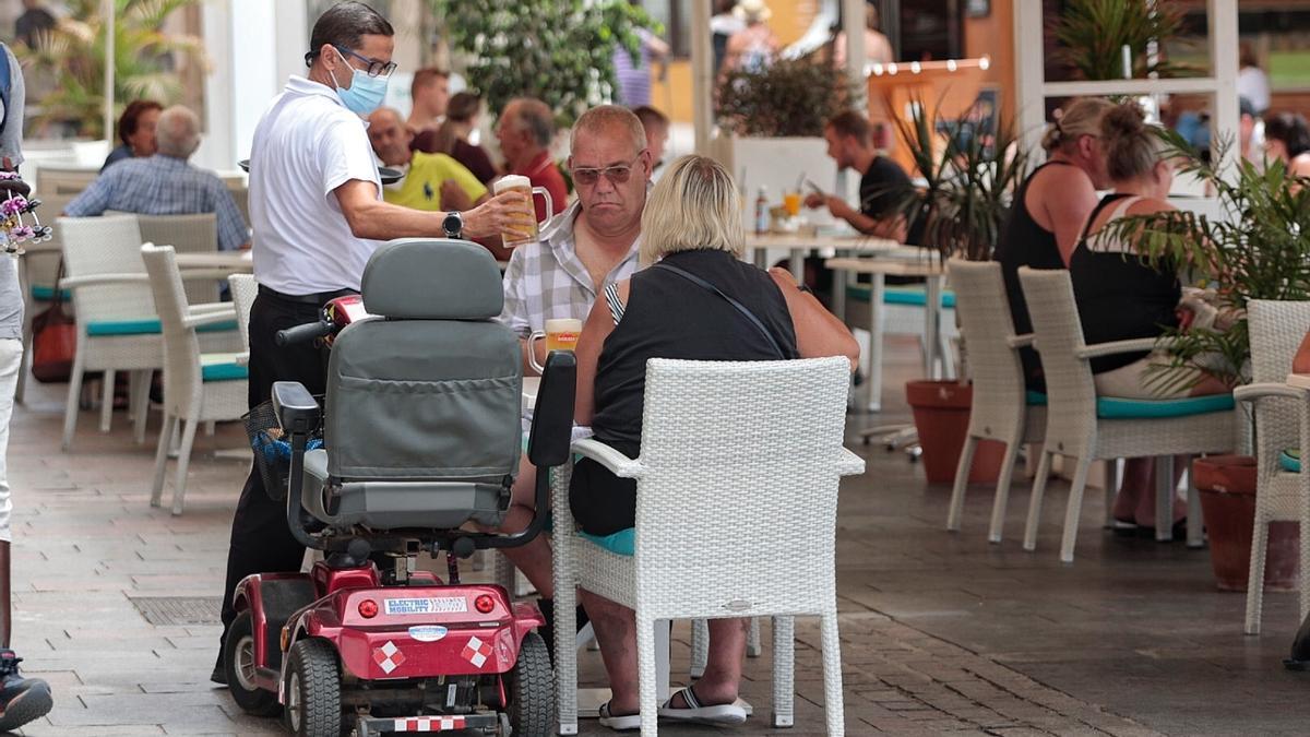 Un camarero sirve una mesa de una terraza en Los Cristianos