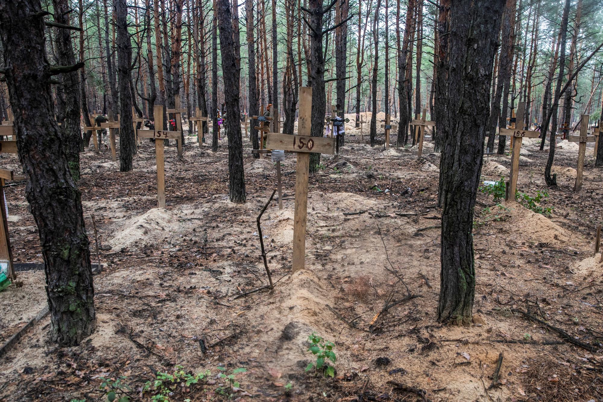 Crosses with numbers are seen at an improvised cemetery of unidentified civilians and Ukrainian soldiers in the town of Izium