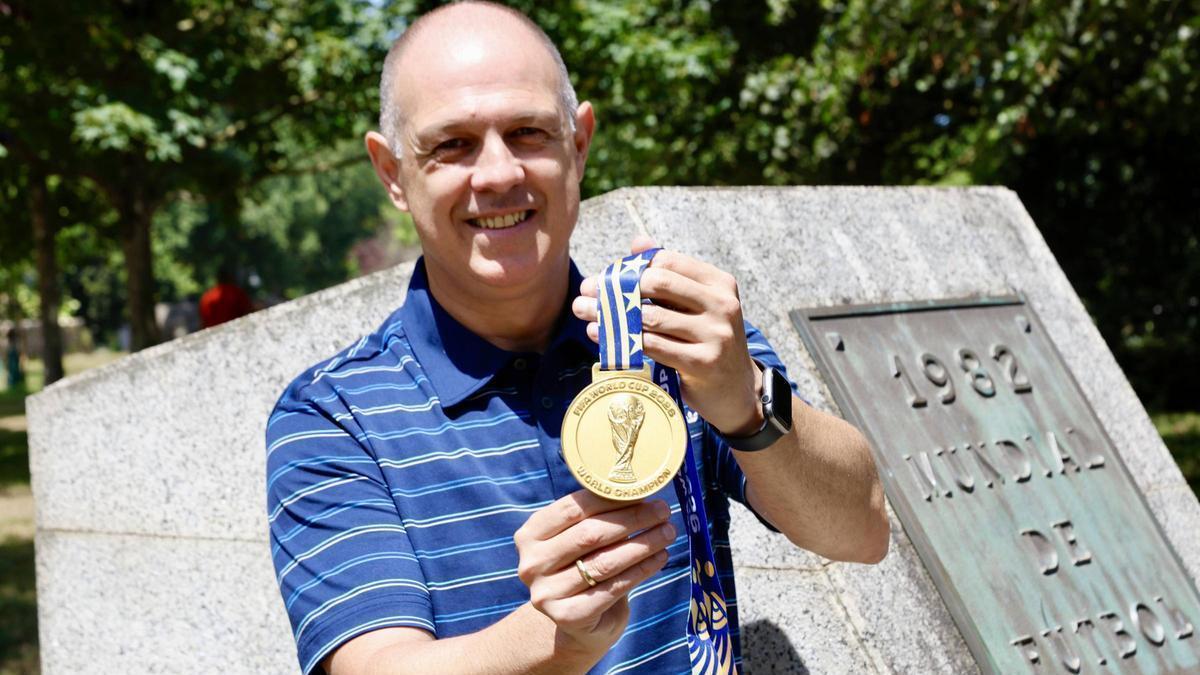 Juanjo González, con la medalla por el triunfo en el Mundial de este verano, ante el monolito que recuerda el Mundial que acogió El Molinón.