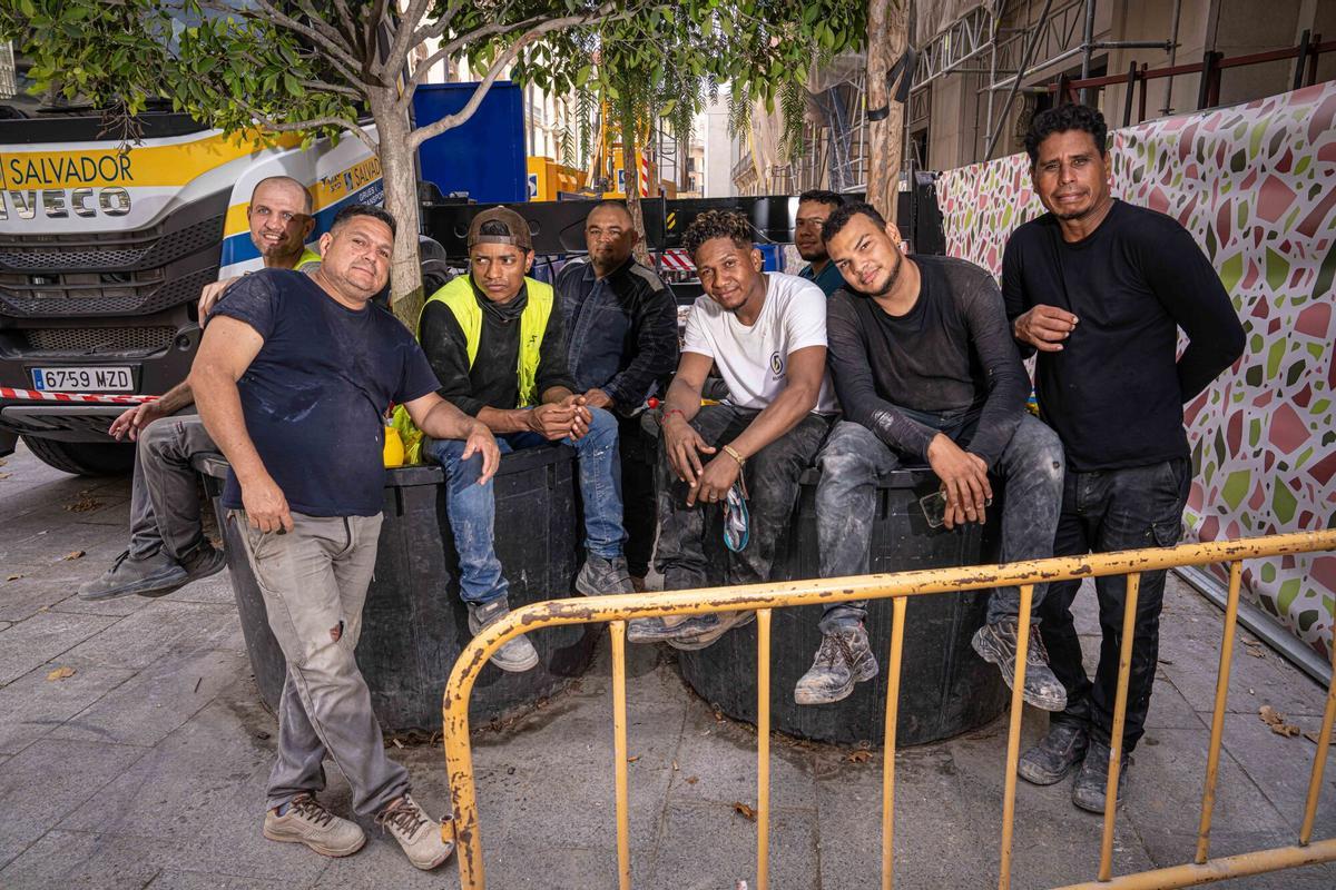 Walter Ruiz, de blanco, junto a sus compañeros de la construcción en el Portal de l'Àngel durante una jornada marcada por el pico de calor. Barcelona, 15 de julio de 2026. AUTOR: Manu Mitru | EPC
