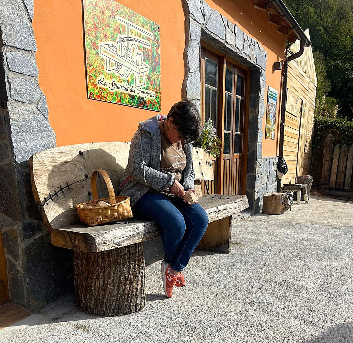 Rosa Cunqueira trabaja una pieza artesana en el exterior de La Guarida del Cunqueiru.