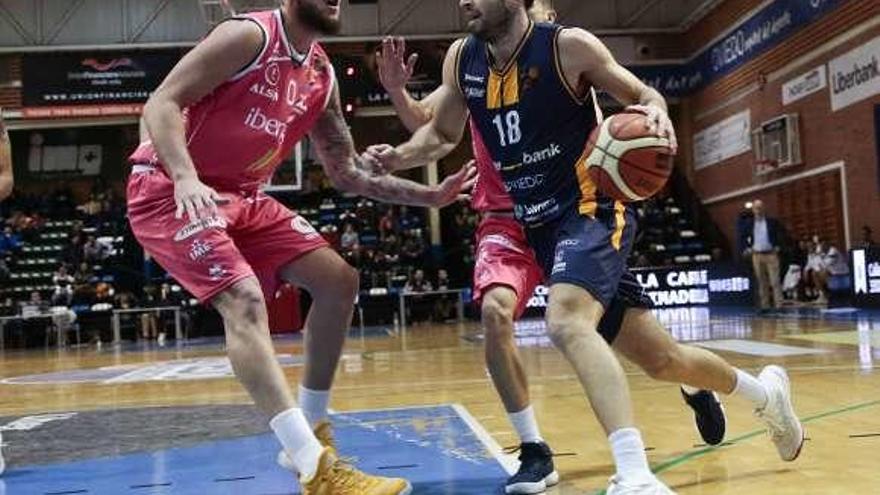 El jugador del Liberbank Oviedo Sergio Llorente, con el balón, defendido por Fran Guerra, del Iberojet Palma.