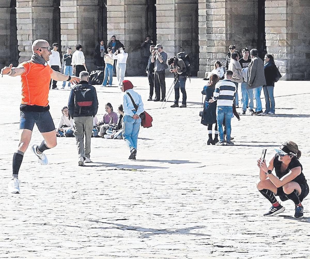 Peregrinos y turistas en la Praza do Obradoiro, este domingo.