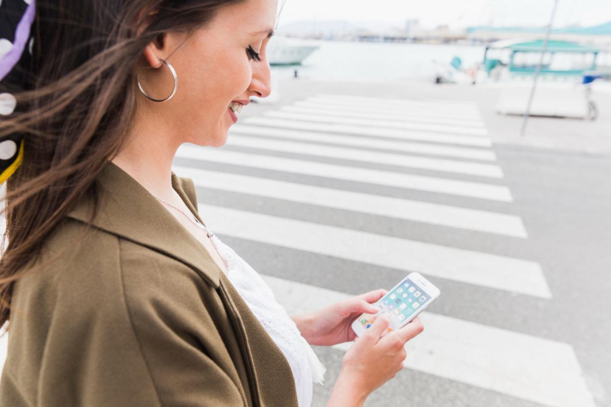 Una mujer se dispone a cruzar la carretera mirando el móvil