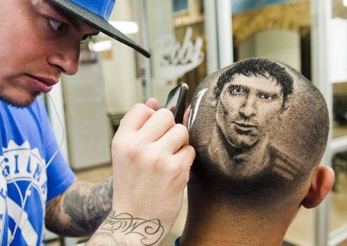 El artista y maestro peluquero Rob Ferrel, hace la replica del futbolista argentino Lionel Messi en la cabeza de un cliente en su barbería en San Antonio antes del partido de la Copa del Mundo entre Argentina y Suiza, en Texas, Estados Unidos.