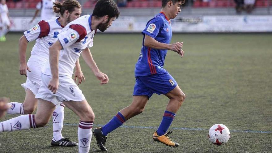 Steven protege la pelota ante dos jugadores del Roces.