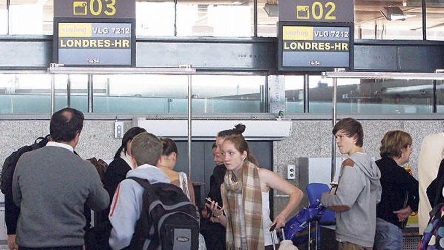 Pasajeros ante el mostrador de facturación de Peinador, en el último vuelo a Londres.  // Marta G. Brea