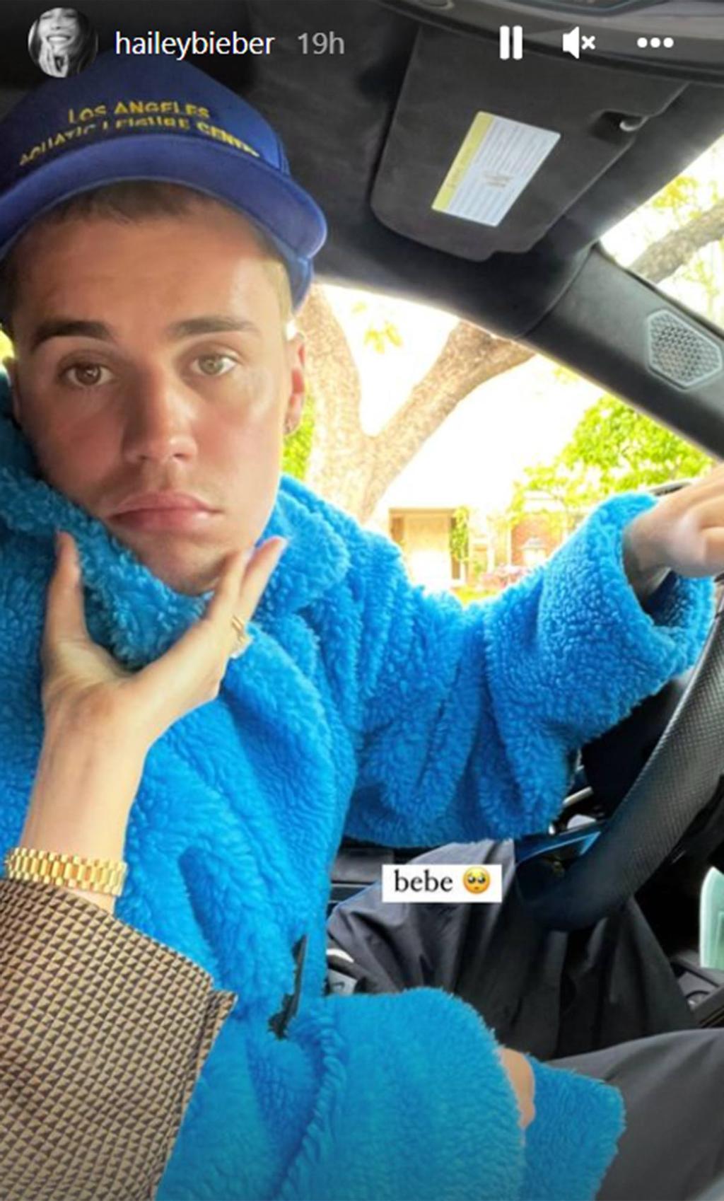Justin Bieber conduciendo mientras Hailey Bieber le hace una caricia