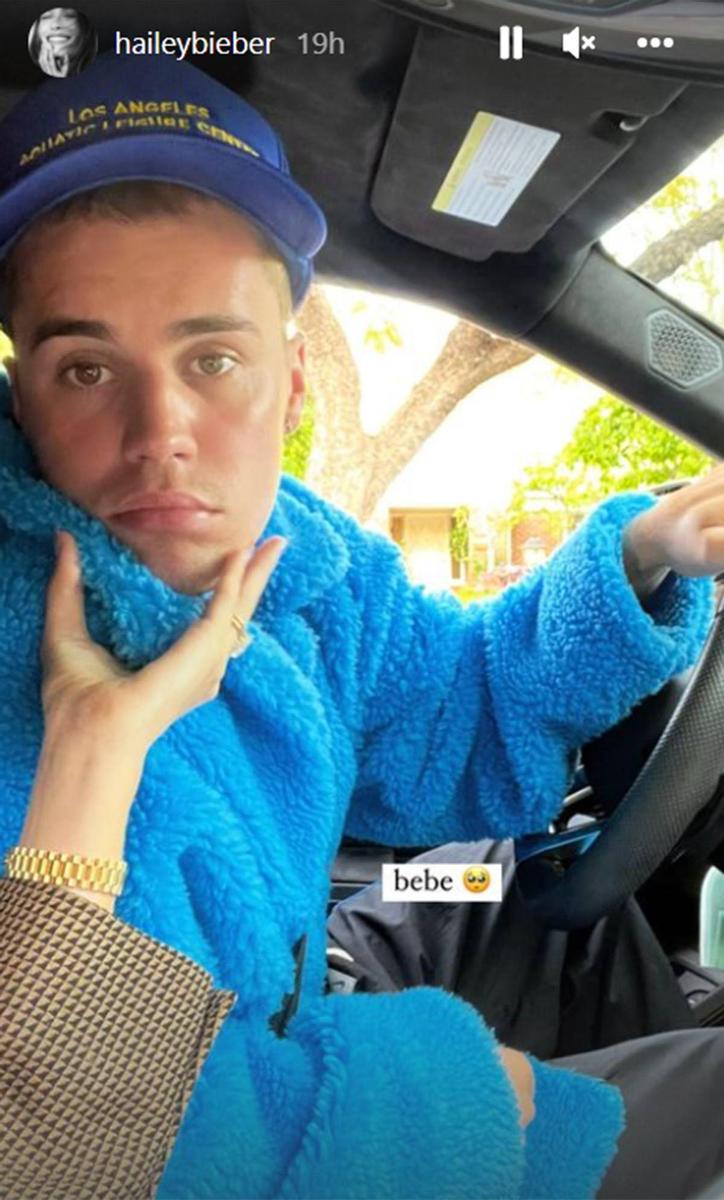 Justin Bieber conduciendo mientras Hailey Bieber le hace una caricia