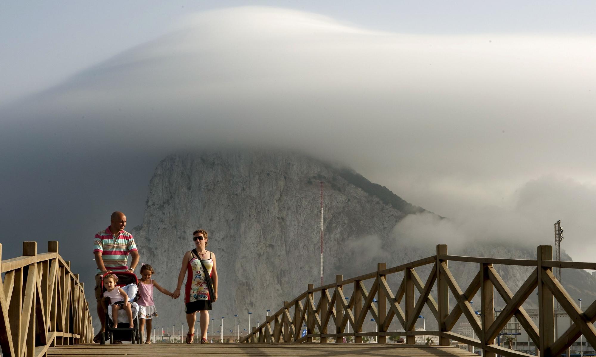 Una familia de La Línea de la Concepción (Cádiz) pasea frente al peñón de Gibraltar