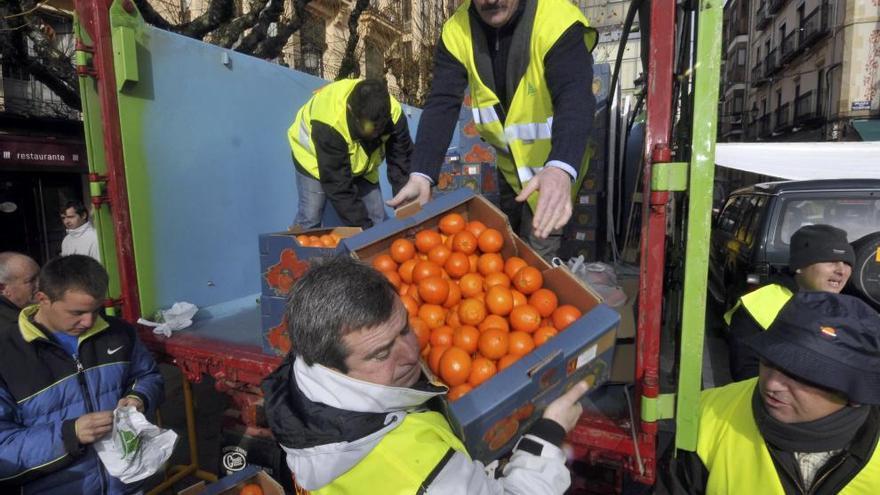 Reparto de naranjas durante una protesta por bajos precios organizada por Asaja