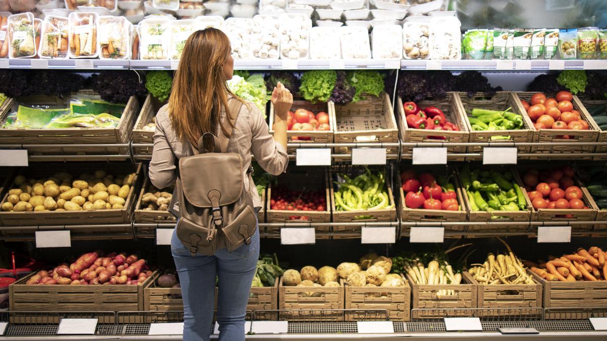 Una clienta ante un puesto de verduras.