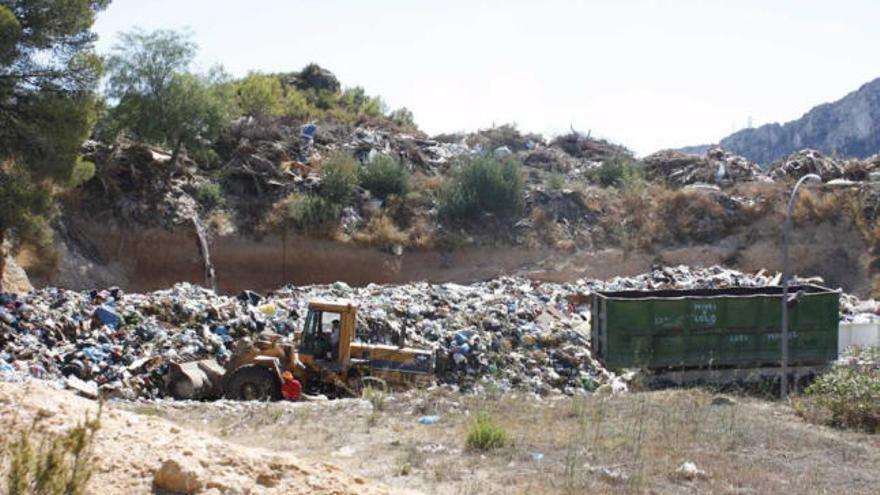 Una pala excavadora y un camión esparcían ayer residuos en el vertedero.