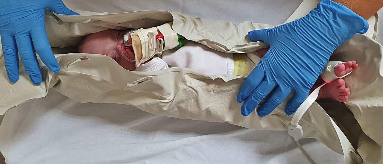 Un bebé en un colchón, en una imagen facilitada por el Hospital General de Elche.