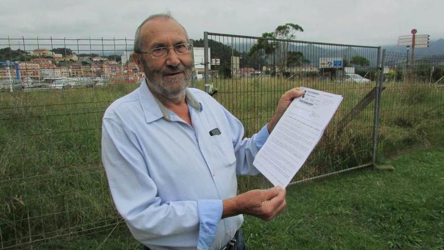 José Luis Valdés, ayer, con la licencia de obras para construir en El Concilio, con la finca detrás.