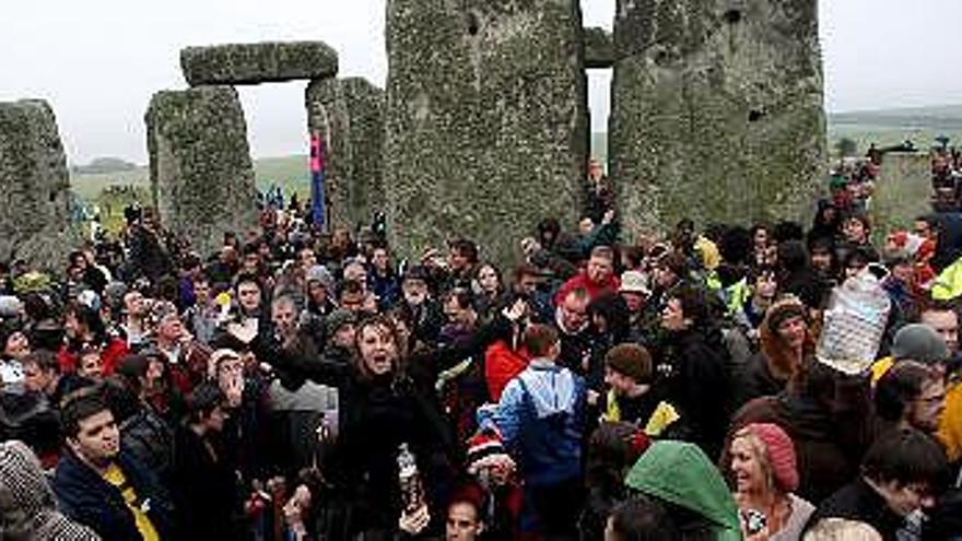 Un grupo de personas acuden al solsticio de verano que celebra el comienzo del día más largo del año en Stonehenge, Wiltshire, Gran Bretaña. Este año el acontecimiento ha reunido a más de 25.000 personas de todo el país y del resto de Europa. Este prehistórico conjunto megalítico de unos 5.000 años de antigüedad y denominado también &quot;El Templo del Sol&quot;, es desde hace varias décadas el lugar elegido para festejar la llegada del verano boreal a Inglaterra.