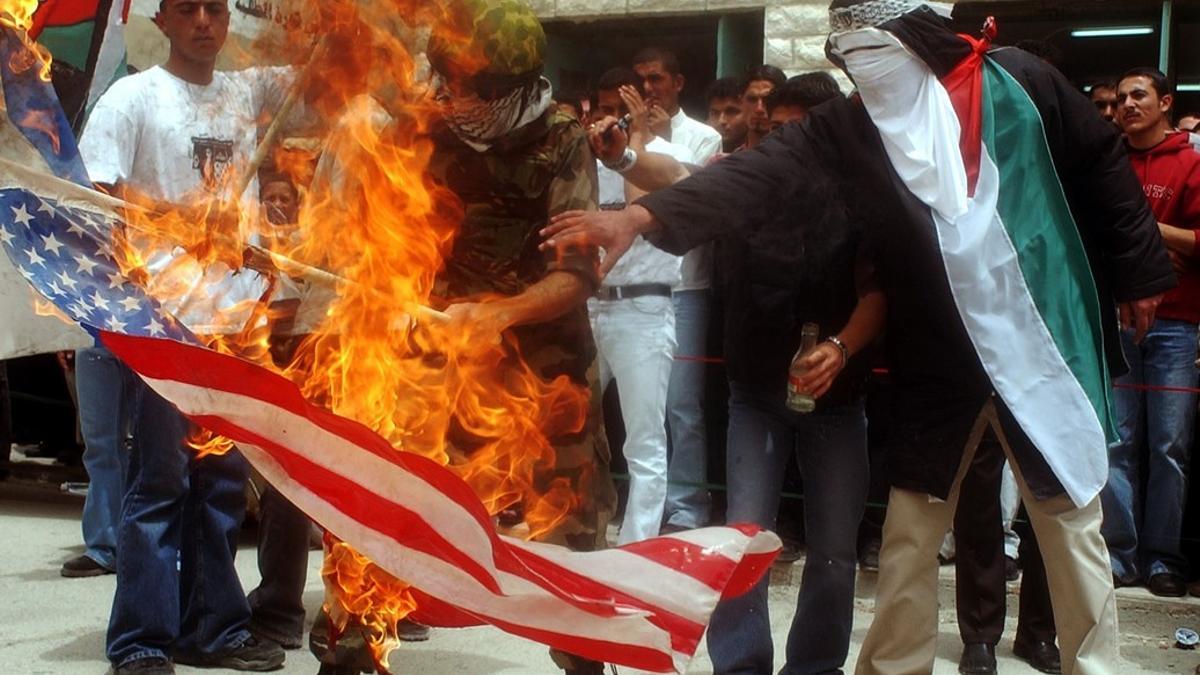 Estudiantes palestinos quemando una bandera de Estados Unidos durante una manifestación anti-israelí en la universidad de Hebrón, en la región de Cisjordania.
