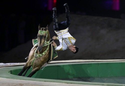 A Turkmenistan man performs on a horse during the opening ceremony of 2014 International Akhal-Teke Horses Association Special Conference and China Horse Culture Festival in Beijing
