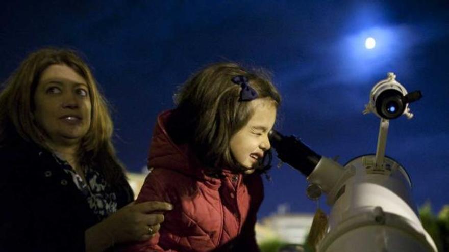 Una niña observa la Luna por un telescopio de la Facultad de Ciencias.
