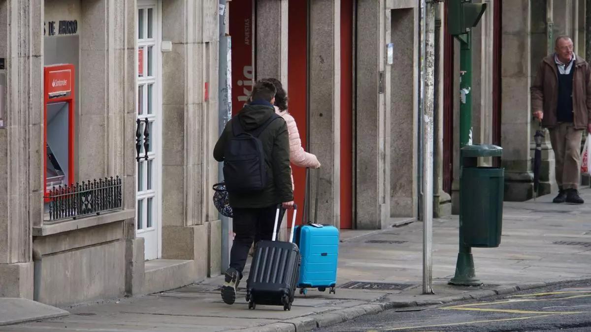 Turistas coas súas maletas polas rúas do centro de Compostela
