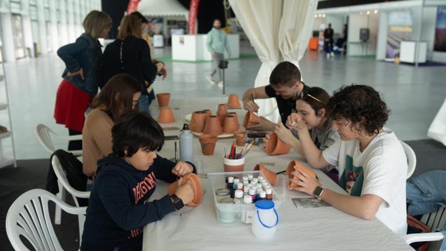 Varios jóvenes participan en el taller de decoración de macetas, una de las actividades de la Feria Mobilizas, en Ifeza. | Emilio Fraile