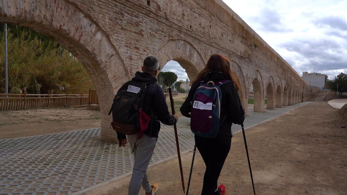 Dos peregrinos pasean junto al Acueducto de Alcantarilla.